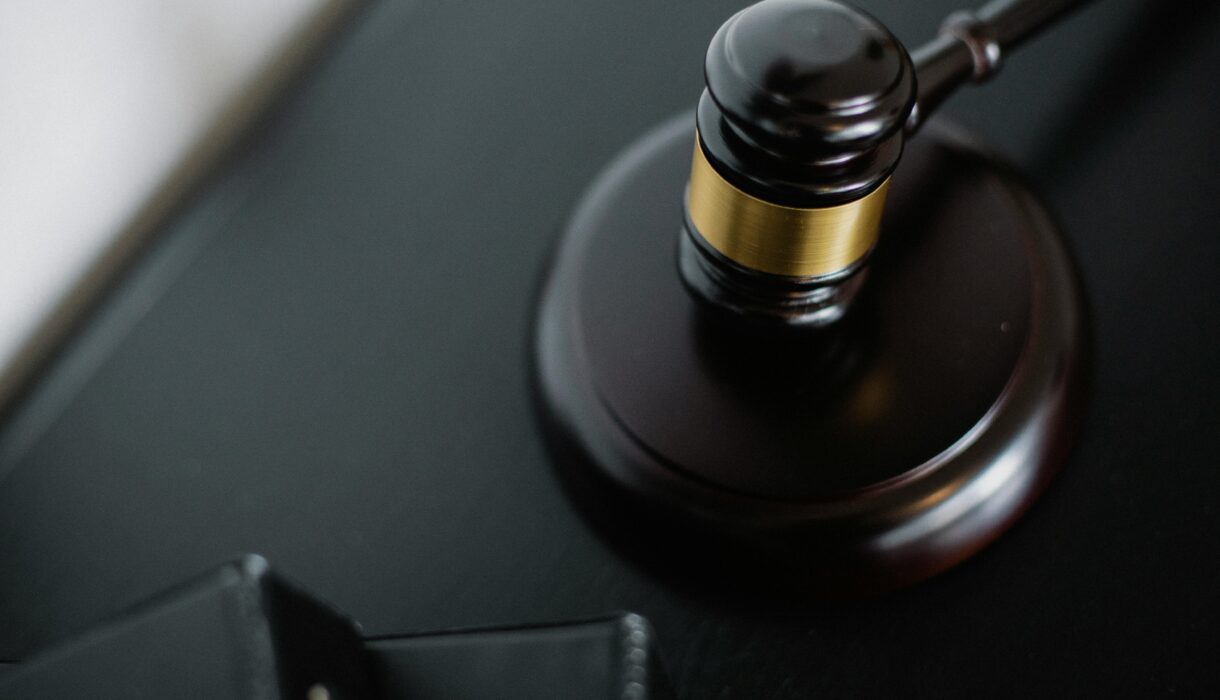 Close-up of a wooden judge's gavel on a black desk, symbolizing justice and law.
